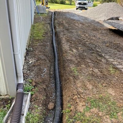 Drainage pipe in trench next to house